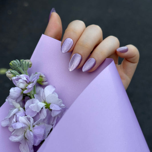 Grape Meteor is a reusable handmade press-on nails set by Leme. High-quality handmade press-on nails in a stunning violet chunky cat-eye finish for maximum sparkle and dimension. Available in various shapes to suit your style. Let violet blooms on your fingertips.