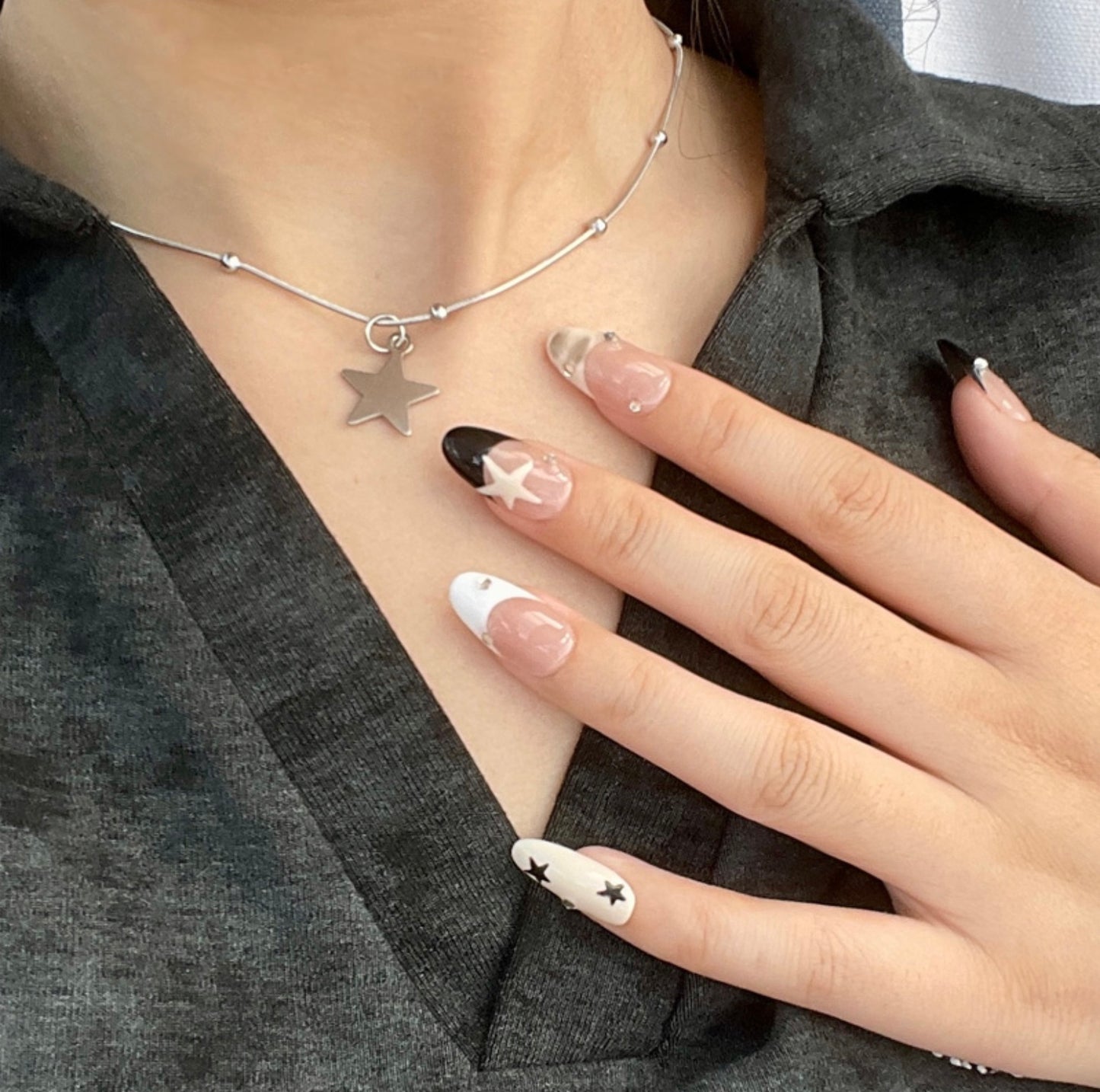 Starry Chic is a reusable handmade press-on nails set by Leme. Elevate your nails with the Starry Chic design, featuring an oval shape and a nude base that highlights cute black and white French tips. Accented with creamy yellow hues, delicate stars, and small diamonds, this high-quality press-on nails set offers a sophisticated yet playful look perfect for any occasion.