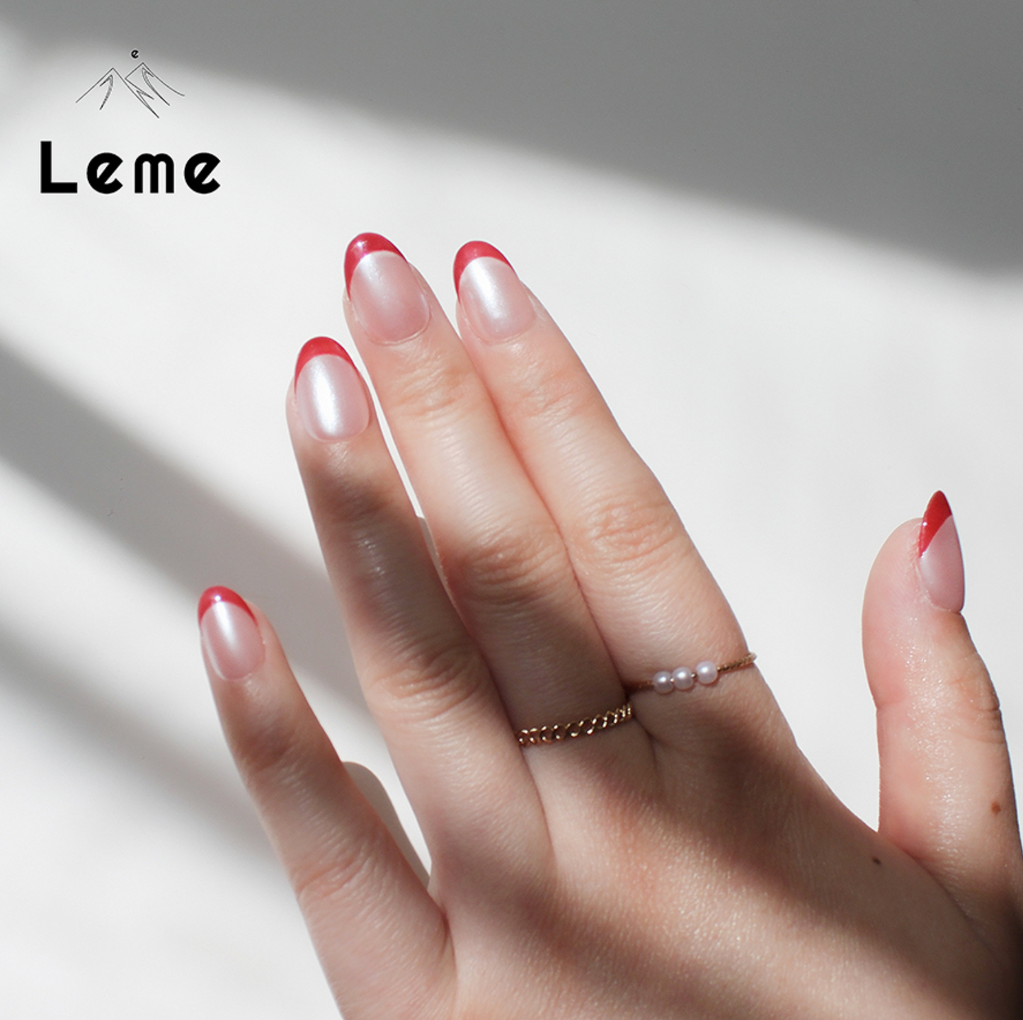 Tiddly Lip is a reusable handmade press-on nails set by Leme. The set offers a sophisticated manicure with its short oval-shaped nails featuring a classic French tip in elegant red and pearl pink tones. Crafted with high-quality chrome finish, these nails provide a sleek, durable look that enhances natural beauty with expert precision. Perfect for a refined, polished appearance.