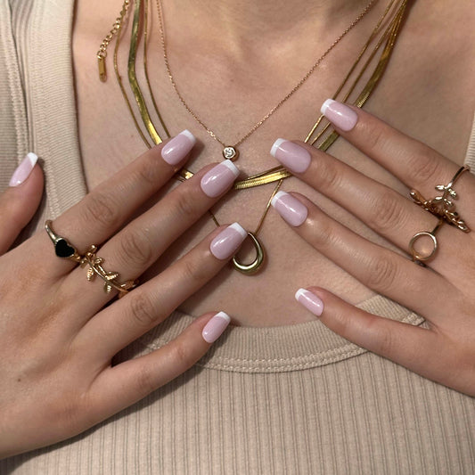 Vanilla Rose is a reusable handmade press-on nails set by Leme. Experience timeless elegance with these high-quality press-on nails featuring a delicate pink base and crisp white French tips. The set comes with multiple shapes and lengths. Perfectly crafted for a sophisticated look, they combine classic style with modern precision to enhance your natural beauty effortlessly. Ideal for any occasion, these nails offer durability and a refined finish that stands out with subtle grace.