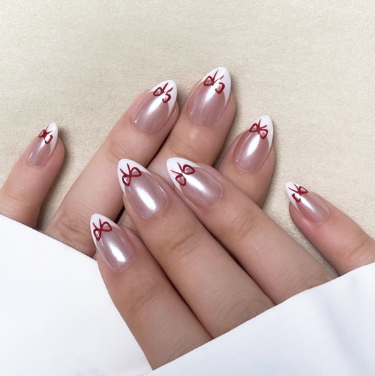 Wish Boxes is a reusable handmade press-on nails set by Leme. These reusable, handmade nails feature a short almond shape with a classic French nude design, accented by an elegant bowtie detail. Crafted with high-quality materials, they offer a sophisticated and natural look perfect for any occasion. Durable and easy to apply, they combine style and practicality for a refined manicure experience.