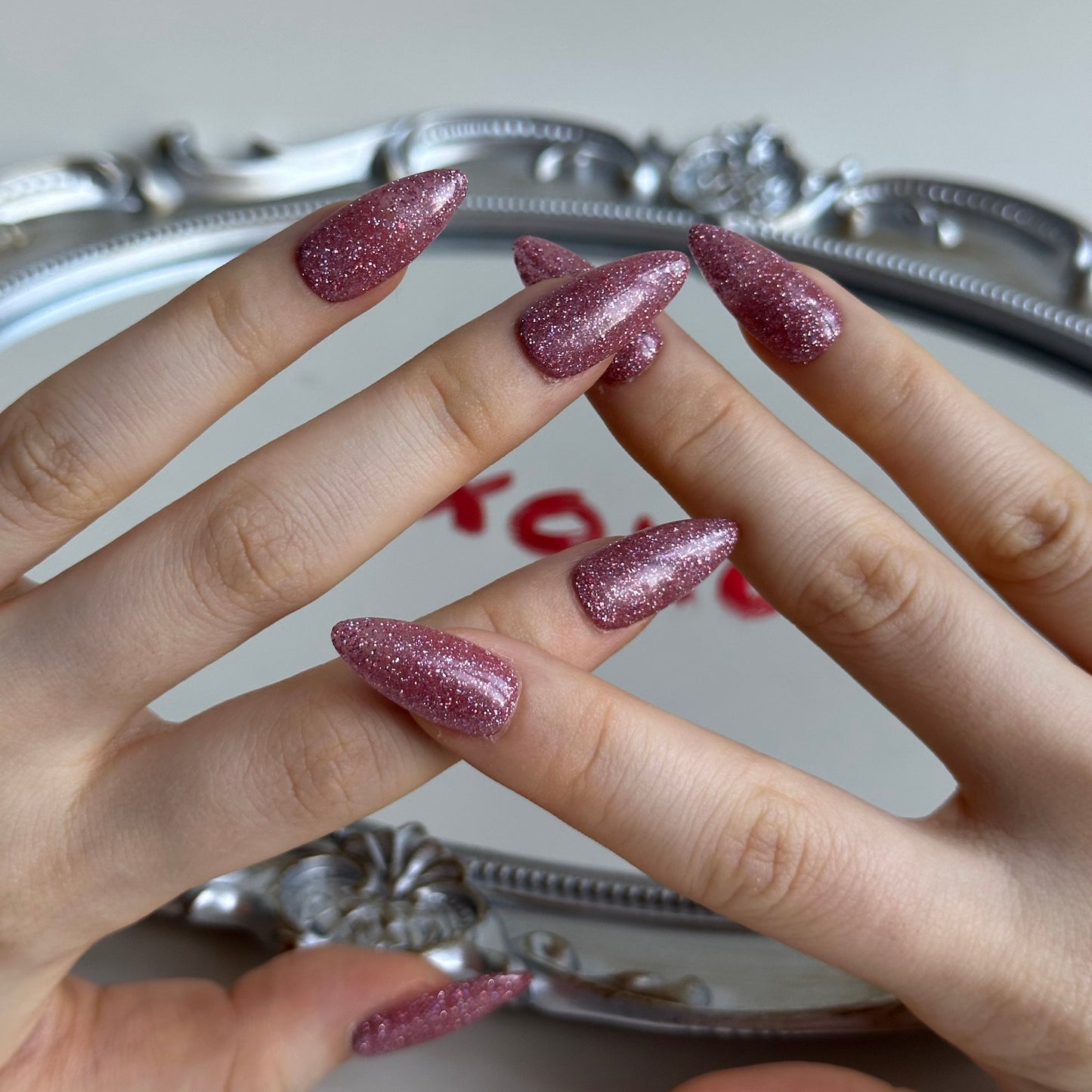 XOXO is a reusable handmade press-on nails set by Leme. Elevate your Valentine's Day look with these exquisite medium almond-shaped nails, expertly crafted with sophisticated light pink glitter. Each nail showcases premium quality materials and meticulous attention to detail, delivering a refined aesthetic that captures romance and elegance. The delicate glitter infusion adds subtle sparkle without overwhelming, making them perfect for both intimate celebrations and special occasions. Whether you're dressin