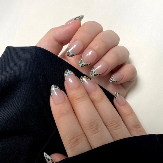 Mint Leopard is a reusable handmade press-on nails set by Leme. Enhance your manicure with these expertly designed French tips featuring a mint-colored leopard pattern. Featuring a nude base and a short almond shape, this design combines subtle elegance with a bold, modern twist. Made with high-quality materials, these nails offer durability and a flawless finish, perfect for those seeking a sophisticated yet trendy look.