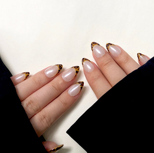 Shiny Pard is a reusable handmade press-on nails set by Leme. The set features expertly crafted short almond-shaped nails with a striking yellow leopard pattern on French tips. Set on a pristine white base and finished with a high-quality white chrome sheen, these nails combine bold design with a polished, durable look. Ideal for those seeking a sophisticated yet adventurous style.