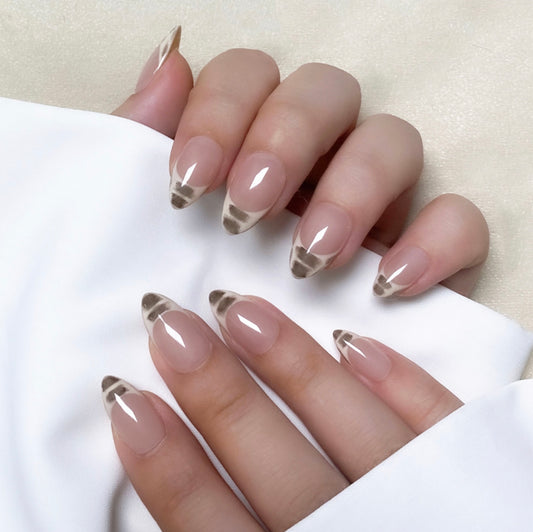 Baby Print is a reusable handmade press-on nails set by Leme. This high-quality nails set features short almond-shaped nails with elegant French tips. The design combines soft nude bases with white and dark brown accents, offering a sophisticated yet fresh look perfect for any occasion.