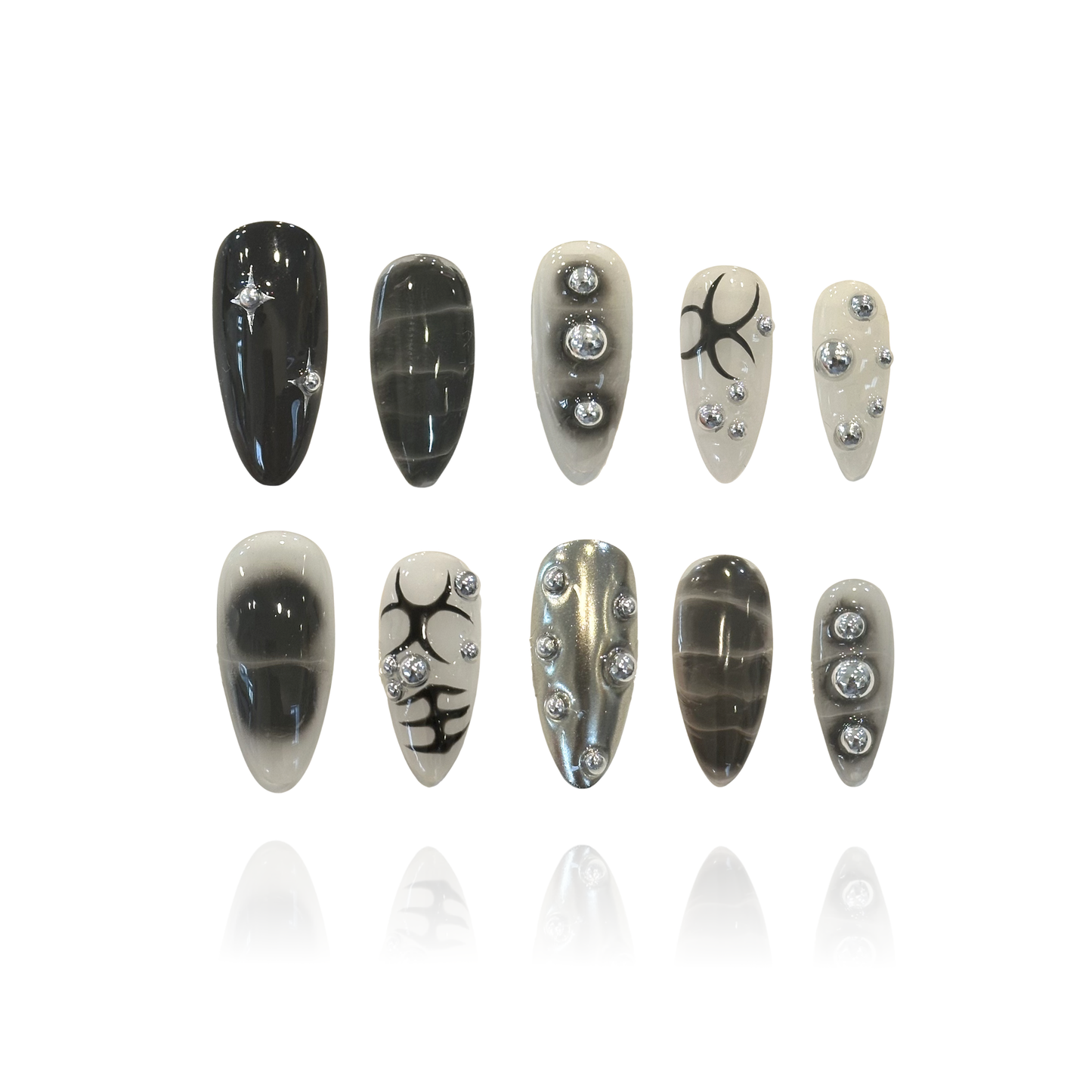 Black Silver Epoch is a reusable handmade press-on nails set by Leme. This set delivers bold, edgy style with a punk rock attitude. Medium almond shape offers a flattering, wearable silhouette that works for everyday wear and statement moments alike. Each set features intricate 3D design work with striking black patterns and silver ball embellishments that catch the light. The dimensional details create depth and texture, elevating these nails beyond flat art—perfect for those who want their manicure to com