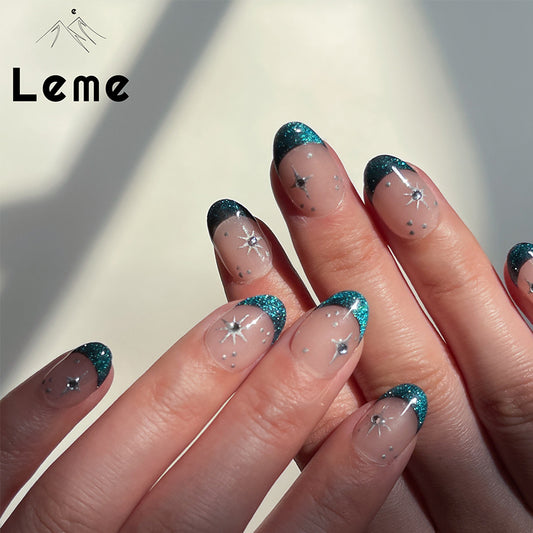 Blue Night is a reusable handmade press-on nails set by Leme. Experience the elegance of our "Blue Night" manicure featuring expertly crafted cat-eye French tips on a subtle nude base. Each short oval-shaped nail is adorned with delicate silver stars and sparkling diamonds, creating a refined and sophisticated look. This design balances understated charm with a touch of luxury, perfect for those seeking a polished and unique style.