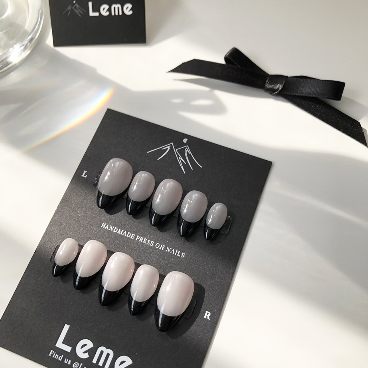 Carina is a reusable handmade press-on nails set by Leme. These sophisticated black French handmade press-on nails feature a chic almond shape, blending modern elegance with timeless style. Meticulously crafted for a precision fit and durability, Leme delivers high-quality results—no appointment needed.