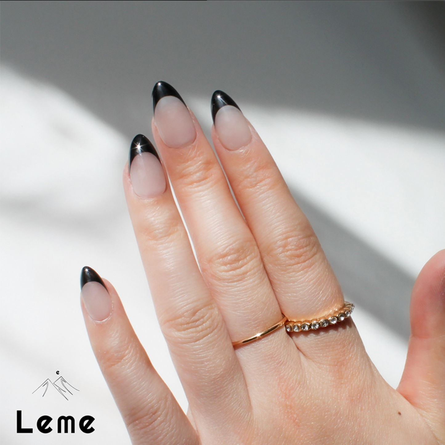 Carina is a reusable handmade press-on nails set by Leme. These sophisticated black French handmade press-on nails feature a chic almond shape, blending modern elegance with timeless style. Meticulously crafted for a precision fit and durability, Leme delivers high-quality results—no appointment needed.