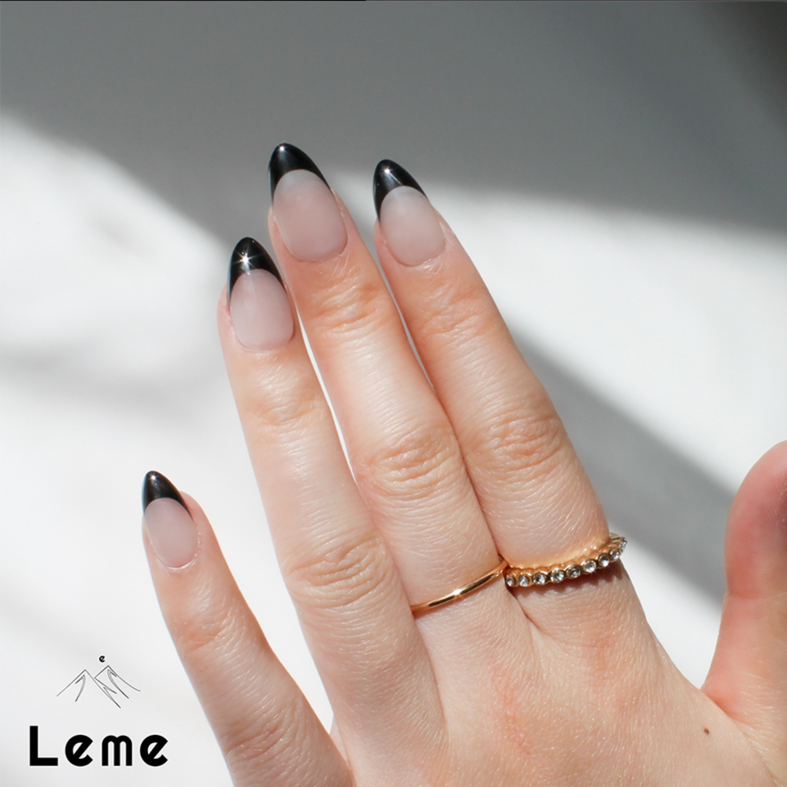 Carina is a reusable handmade press-on nails set by Leme. These sophisticated black French handmade press-on nails feature a chic almond shape, blending modern elegance with timeless style. Meticulously crafted for a precision fit and durability, Leme delivers high-quality results—no appointment needed.