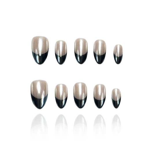 Carina ‘C is a reusable handmade press-on nails set by Leme. Elevate your nail game with Carina ‘C, featuring a sophisticated short almond shape that combines a nude base with striking black French tips. Crafted with high-quality materials and finished with a sleek chrome effect, this design offers a modern, polished look perfect for any occasion. Durable and stylish, these nails provide a flawless finish that enhances your natural elegance.
