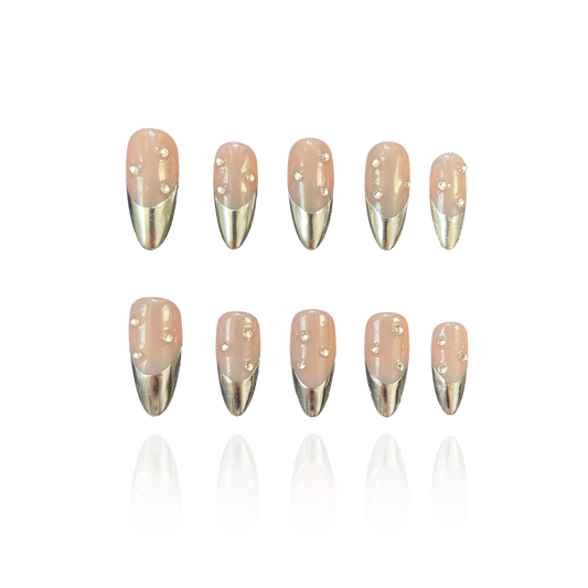 Cold Mirror is a reusable handmade press-on nails set by Leme. Elevate your nail game with Cold Mirror, featuring expertly crafted almond-shaped 3D nails in a sophisticated nude base. These high-quality nails showcase striking gold chrome French tips, blending modern elegance with a subtle metallic sheen. Perfect for those seeking a refined yet eye-catching manicure that lasts.