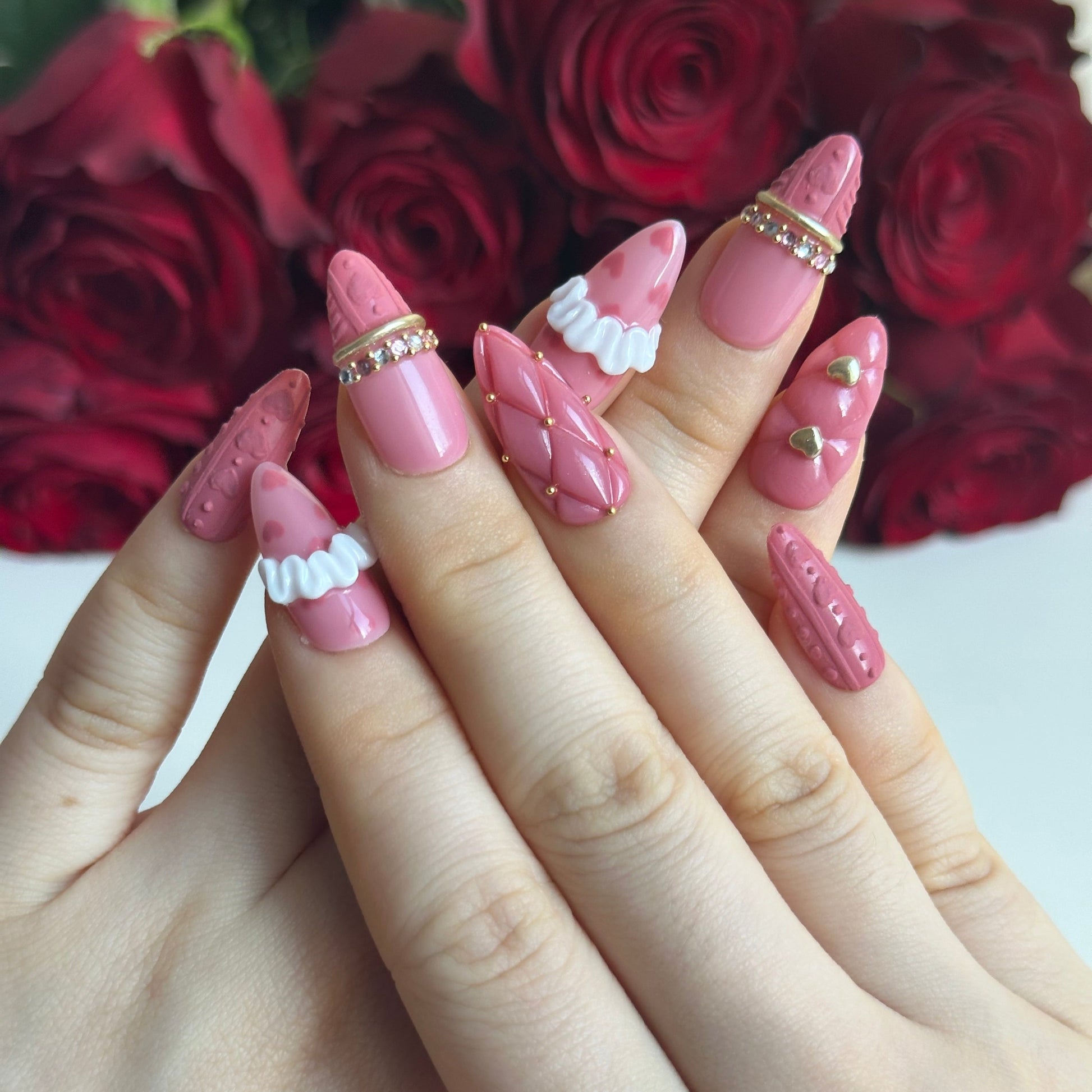 Gold Promise is a reusable handmade press-on nails set by Leme. Discover Gold Promise, an exquisite nail collection that captures timeless elegance through meticulous craftsmanship. These medium almond-shaped nails feature a romantic pink base paired with classic French tips adorned in a soft sweater texture for subtle sophistication. The design showcases premium 3D embellishments complemented by strategically placed gems and gold chrome accents that form delicate ring-like details across the nail surface. 