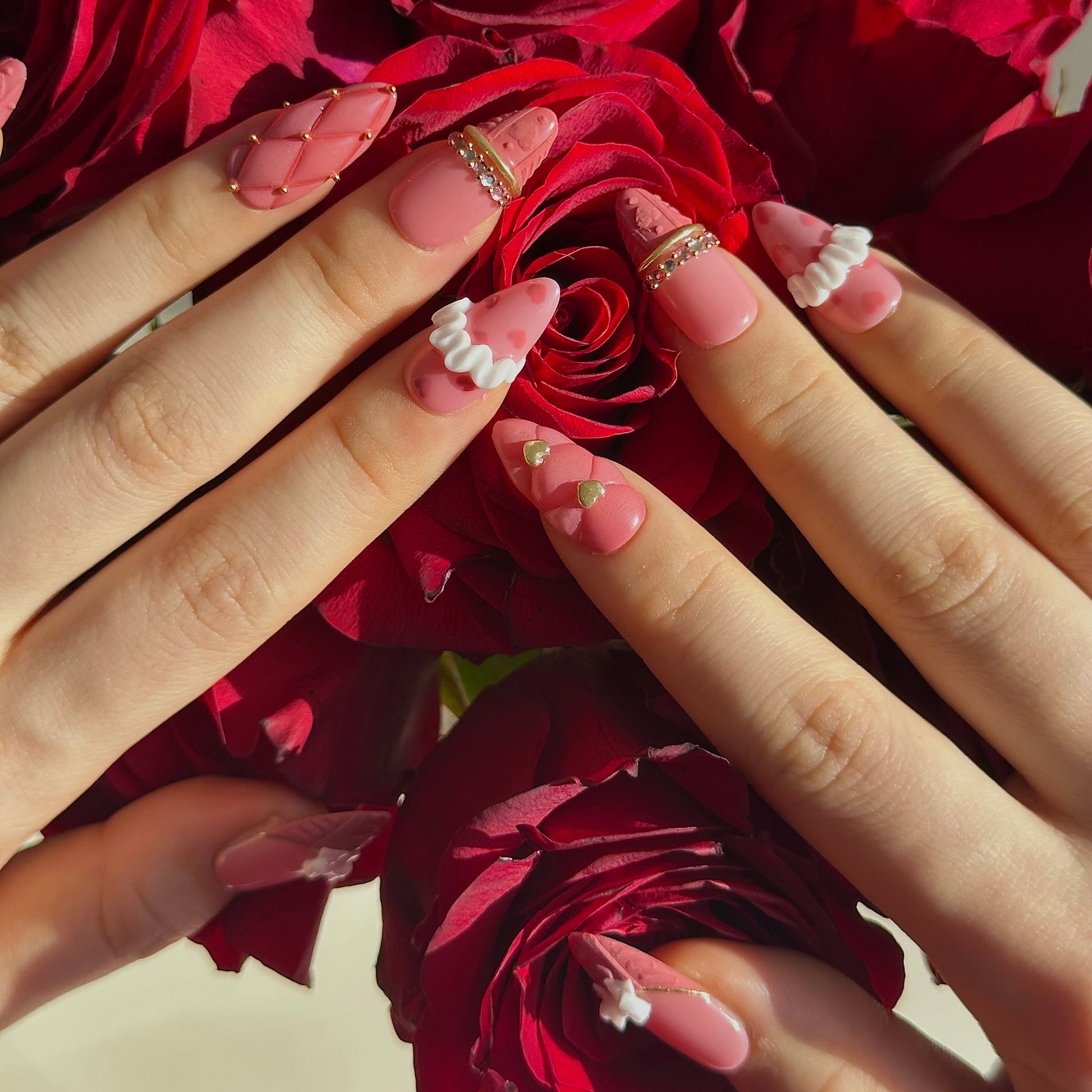 Gold Promise is a reusable handmade press-on nails set by Leme. Discover Gold Promise, an exquisite nail collection that captures timeless elegance through meticulous craftsmanship. These medium almond-shaped nails feature a romantic pink base paired with classic French tips adorned in a soft sweater texture for subtle sophistication. The design showcases premium 3D embellishments complemented by strategically placed gems and gold chrome accents that form delicate ring-like details across the nail surface. 