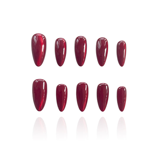 Hickey is a reusable handmade press-on nails set by Leme. Make a statement this Valentine's Day with these expertly designed press-on nails. Featuring a sophisticated medium almond shape and striking hot red cat-eye design, they deliver instant glamour and a distinctly sexy aesthetic. Each nail is crafted from premium materials for superior durability and a flawless finish. Quick to apply and built to last, these nails are your shortcut to salon-quality elegance without the commitment.