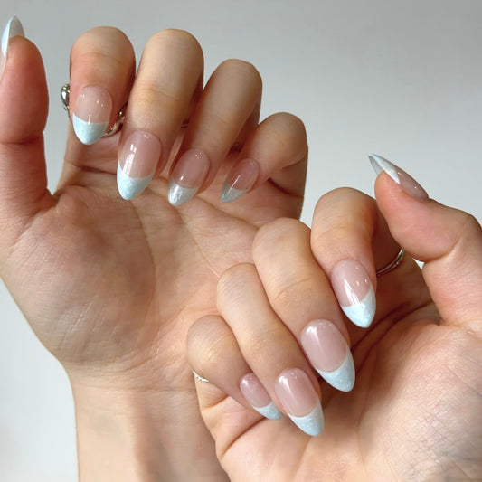 Pearly Cloud is a reusable handmade press-on nails set by Leme. The set brings timeless elegance to your fingertips. These high-quality almond-shaped press-on nails feature a sophisticated white nude base with delicate blue pearl thread French tips, creating a refined and understated look. Perfect for those who appreciate classic beauty with subtle detail, this design transitions effortlessly from everyday wear to special occasions. Simple yet stunning.
