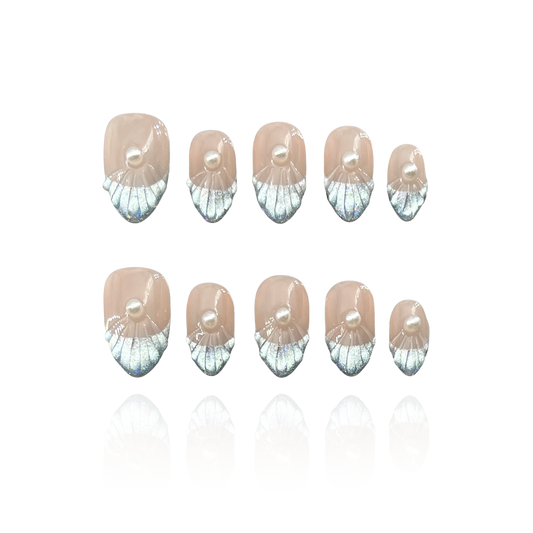 Pearly Wave is a reusable handmade press-on nails set by Leme. The set features expertly crafted short almond-shaped nails with silver-blue cat-eye French tips. Enhanced by delicate wave patterns and pearl accents, these high-quality nails showcase a refined shell grain finish for a sophisticated, elegant look. Perfect for those seeking a subtle yet striking manicure.