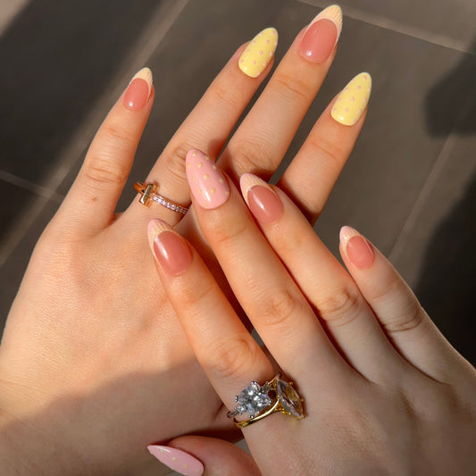 Sugar Dots is a reusable handmade press-on nails set by Leme. Delicate almond-shaped press-on nails featuring soft pink and yellow French tips adorned with charming snowflake sand detailing. Sparkle polka dots dance across each nail for an enchanting, playful look. Perfect for adding a touch of dessert-inspired elegance to your manicure. High-quality construction ensures durability and a flawless finish every time.