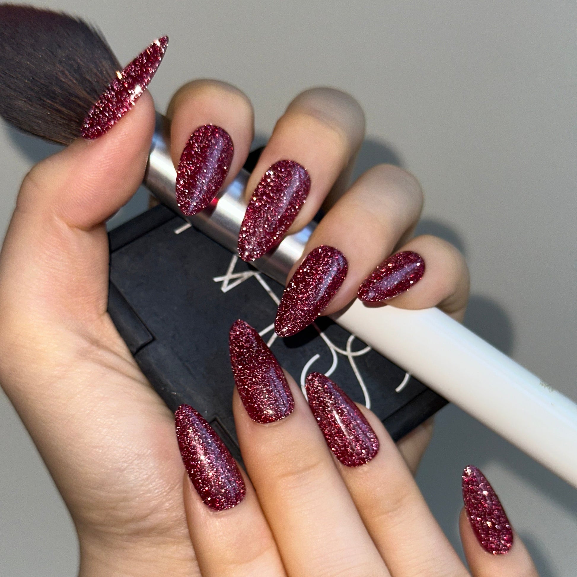 Sweatheart is a reusable handmade press-on nails set by Leme.Elevate your Valentine's Day look with these stunning medium almond-shaped nails featuring a sophisticated raspberry pink glitter base. Each nail is meticulously crafted with premium quality materials to ensure durability and a flawless finish. The intricate firework alike design adds depth and dimension, creating a captivating sparkle that catches the light beautifully. Perfect for the season of love, these nails deliver both elegance and eye-cat