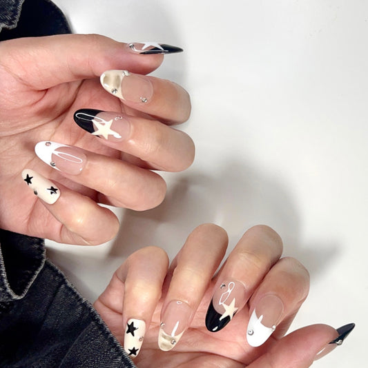 Starry Chic is a reusable handmade press-on nails set by Leme. Elevate your nails with the Starry Chic design, featuring an oval shape and a nude base that highlights cute black and white French tips. Accented with creamy yellow hues, delicate stars, and small diamonds, this high-quality press-on nails set offers a sophisticated yet playful look perfect for any occasion.