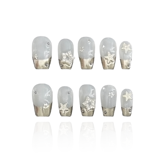 Twinkle is a reusable handmade press-on nails set by Leme. Elevate your manicure with Twinkle, featuring a chic short coffin shape and elegant silver chrome French tips. Adorned with shiny silver stars, this high-quality design offers a sophisticated sparkle perfect for your fingertips. 