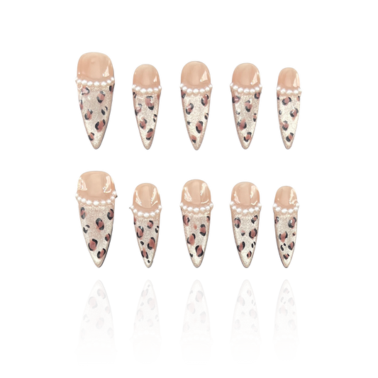 Wild Cat is a reusable handmade press-on nails set by Leme. Elevate your nail game with "Wild Cat," featuring expertly crafted long stiletto nails adorned with chic cat-eye French tips. This high-quality set combines elegant nude tones with striking leopard patterns and delicate pearl accents, delivering a sophisticated yet bold look perfect for those who appreciate refined artistry and daring style.