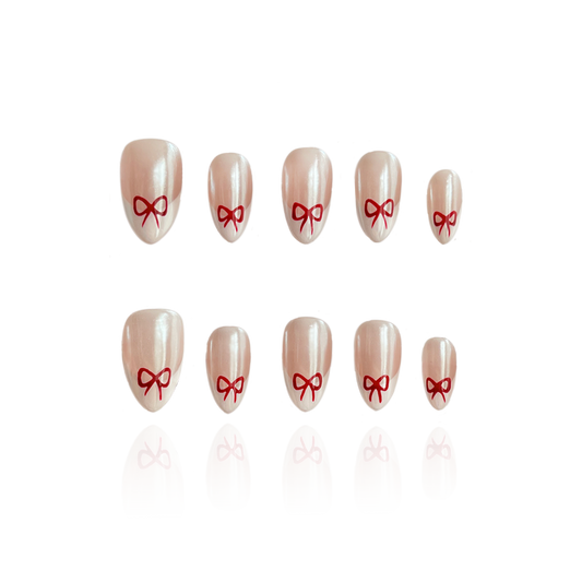 Wish Boxes is a reusable handmade press-on nails set by Leme. These reusable, handmade nails feature a short almond shape with a classic French nude design, accented by an elegant bowtie detail. Crafted with high-quality materials, they offer a sophisticated and natural look perfect for any occasion. Durable and easy to apply, they combine style and practicality for a refined manicure experience.
