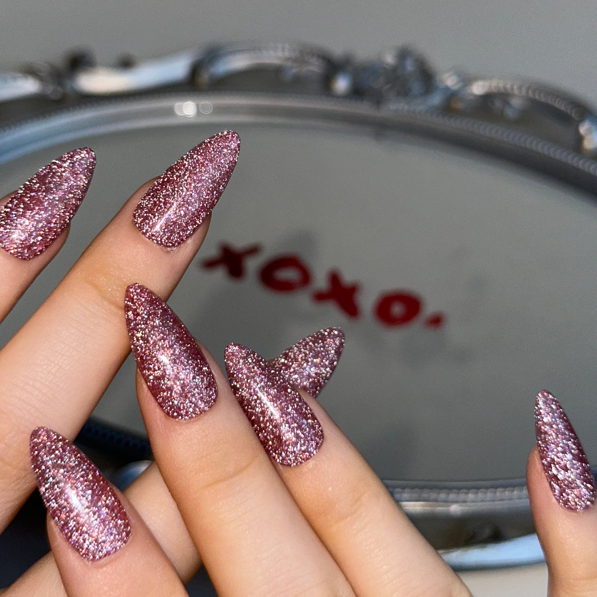 XOXO is a reusable handmade press-on nails set by Leme. Elevate your Valentine's Day look with these exquisite medium almond-shaped nails, expertly crafted with sophisticated light pink glitter. Each nail showcases premium quality materials and meticulous attention to detail, delivering a refined aesthetic that captures romance and elegance. The delicate glitter infusion adds subtle sparkle without overwhelming, making them perfect for both intimate celebrations and special occasions. Whether you're dressin