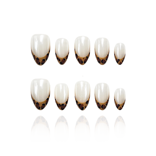 Shiny Pard is a reusable handmade press-on nails set by Leme. The set features expertly crafted short almond-shaped nails with a striking yellow leopard pattern on French tips. Set on a pristine white base and finished with a high-quality white chrome sheen, these nails combine bold design with a polished, durable look. Ideal for those seeking a sophisticated yet adventurous style.