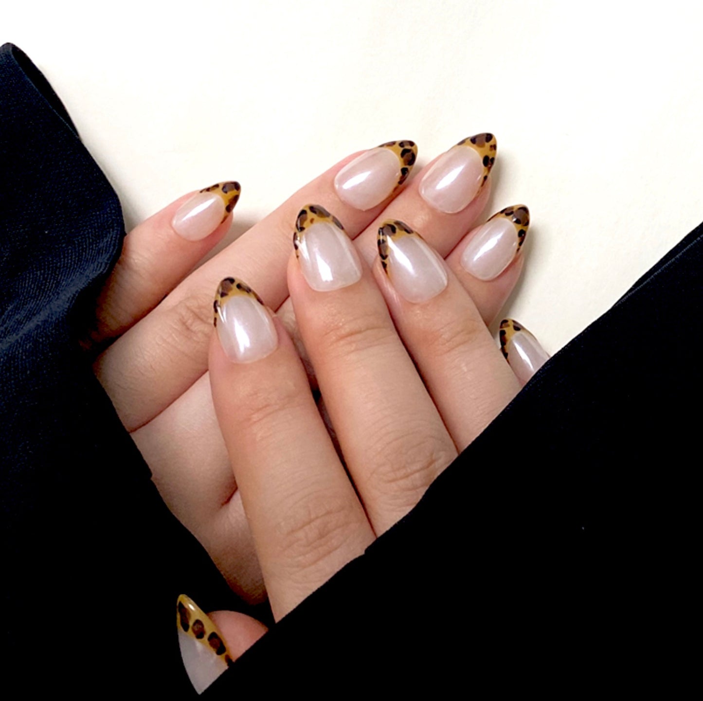 Shiny Pard is a reusable handmade press-on nails set by Leme. The set features expertly crafted short almond-shaped nails with a striking yellow leopard pattern on French tips. Set on a pristine white base and finished with a high-quality white chrome sheen, these nails combine bold design with a polished, durable look. Ideal for those seeking a sophisticated yet adventurous style.