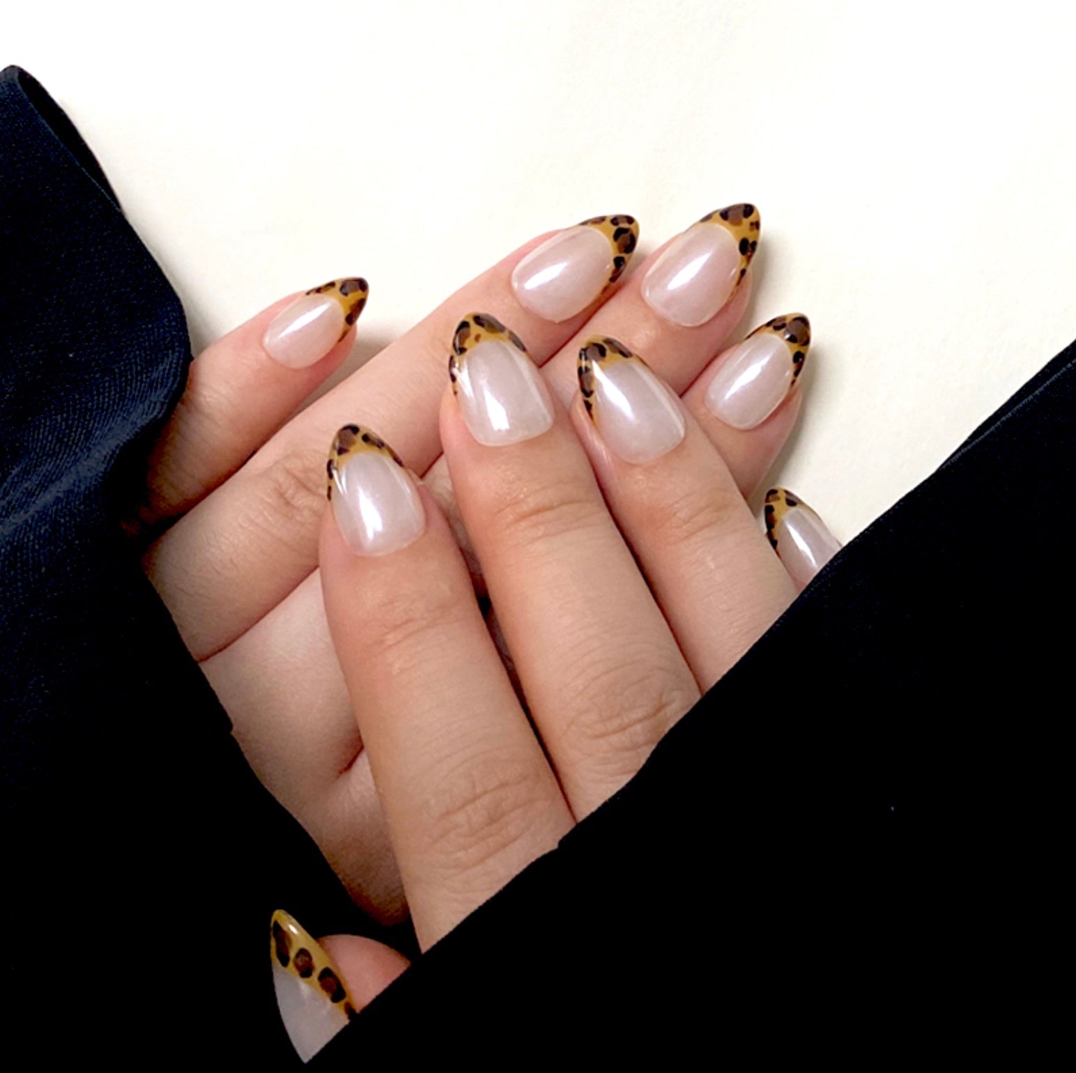 Shiny Pard is a reusable handmade press-on nails set by Leme. The set features expertly crafted short almond-shaped nails with a striking yellow leopard pattern on French tips. Set on a pristine white base and finished with a high-quality white chrome sheen, these nails combine bold design with a polished, durable look. Ideal for those seeking a sophisticated yet adventurous style.